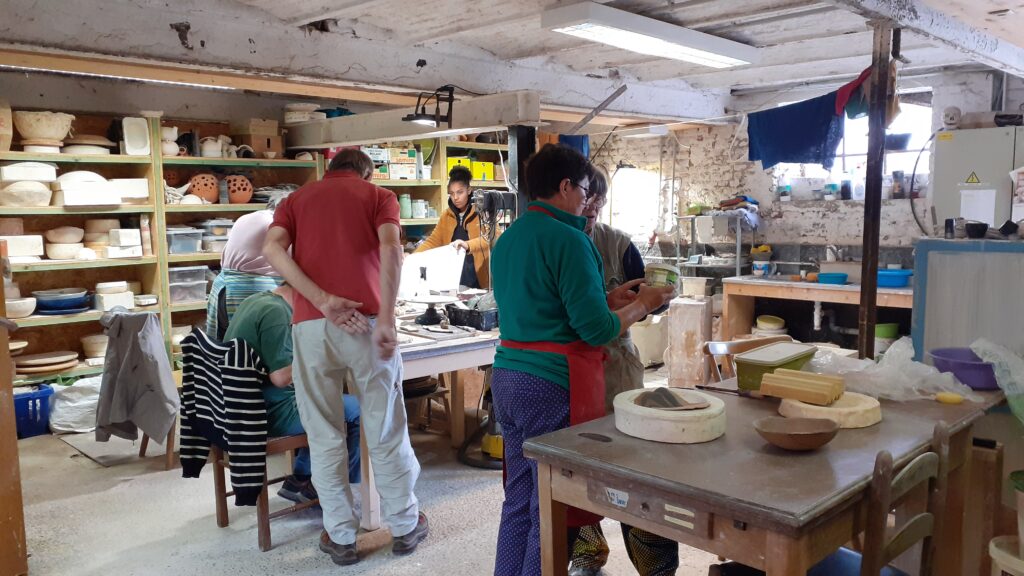 Les participants au cour de poterie s'activent dans l'atelier, qui avec un moule en plâtre, qui à faire des plaques de terre. Toutes les techniques sont possibles